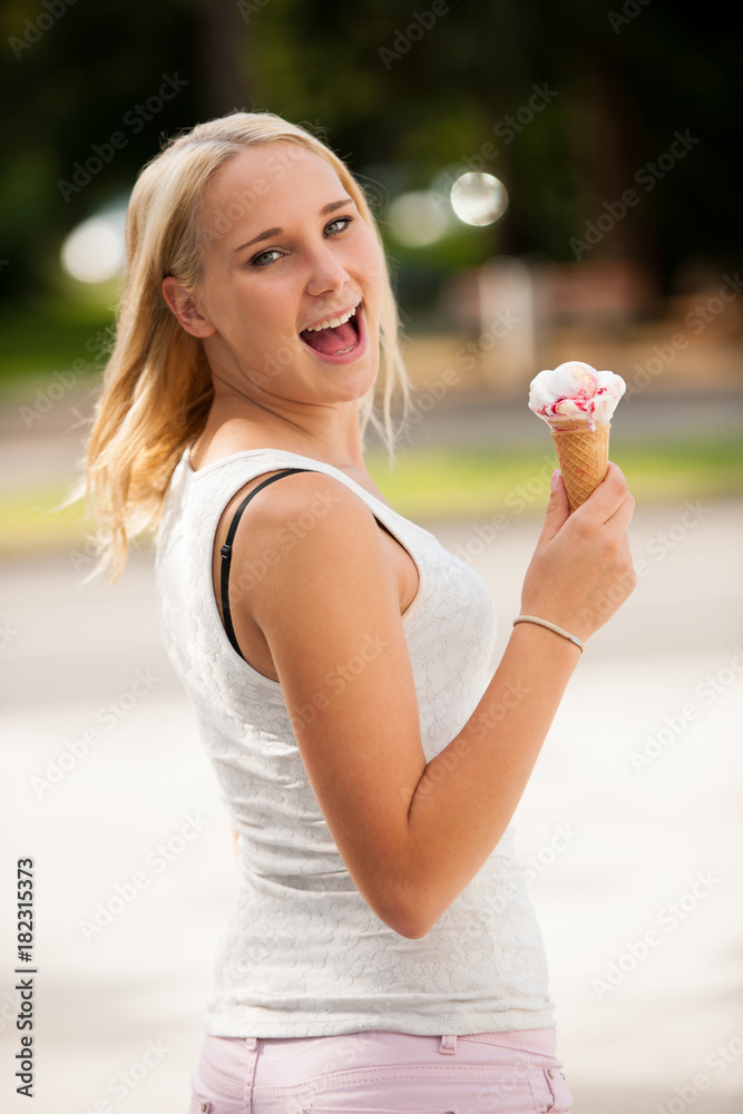 Woman eating ice cream in a park on a hot summer day