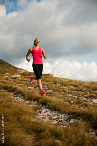 runner - woman runs cros country on a path in early autumn