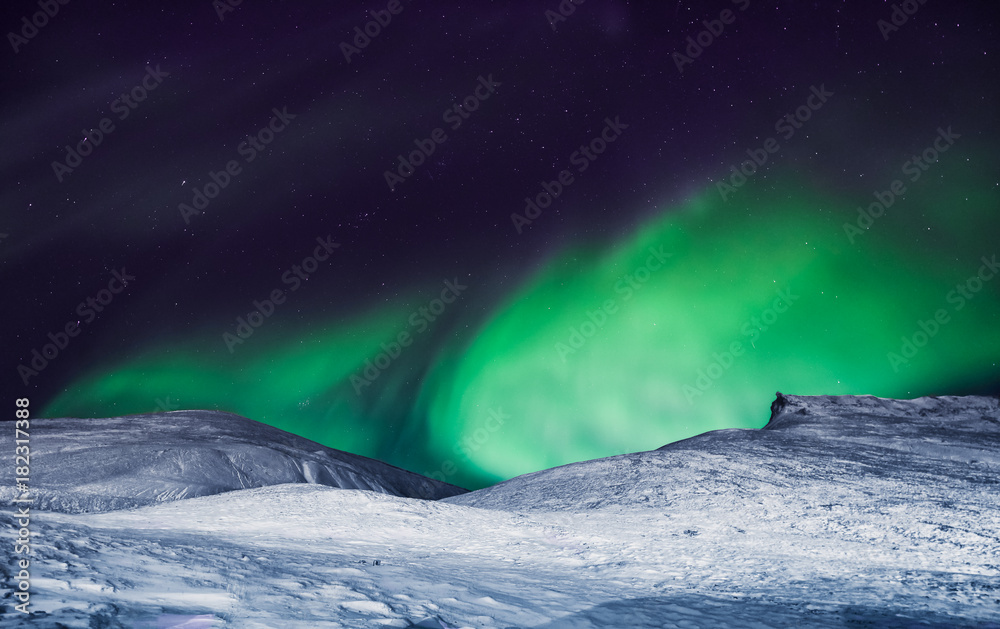 Naklejka premium The polar arctic Northern lights aurora borealis sky star in Norway Svalbard in Longyearbyen city the moon mountains