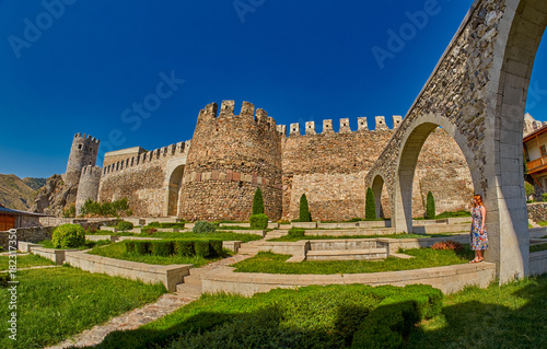 Young woman tourist against massive walls of Rabati Castle