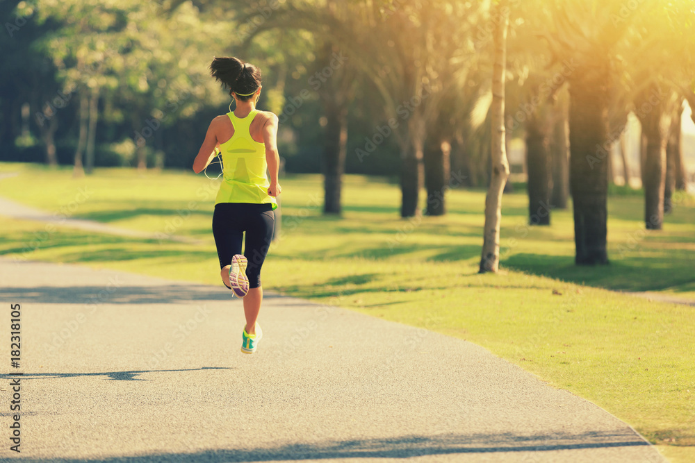 Young fitness woman running at tropical park Young fitness woman running at tropical park