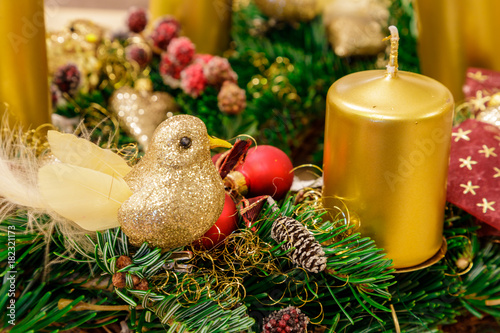 Beaty christmas decoration in the needles with candles, gold birdand red balls. photo