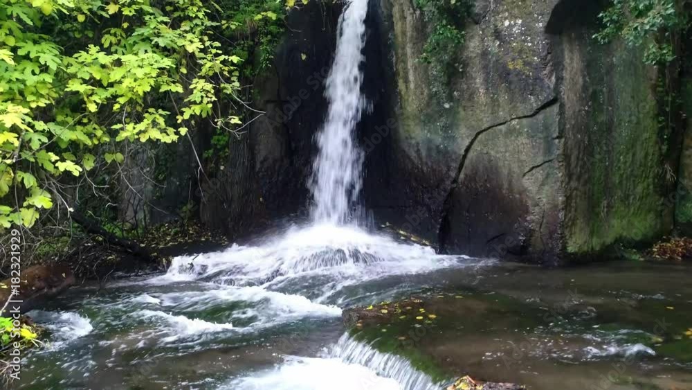 Waterfall in a river between rocks and trees Waterfall in a river between rocks and trees