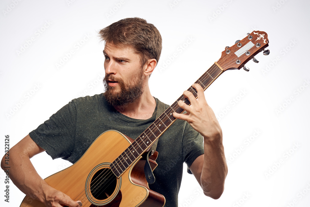 Obraz premium Man with a beard on a white isolated background holds a guitar, musical instruments, music