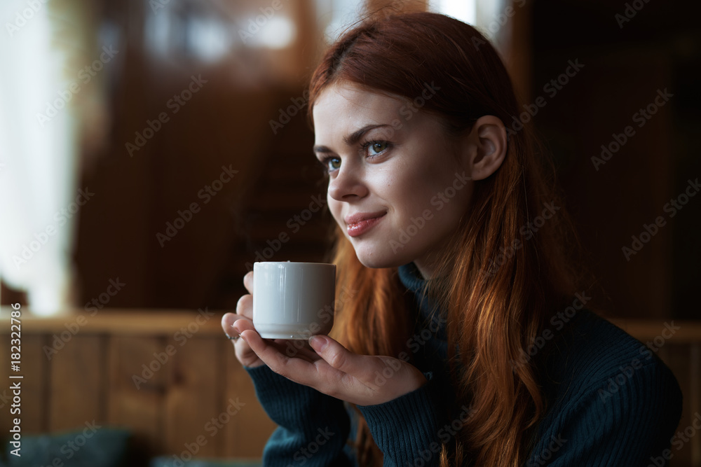 Young beautiful woman drinks coffee in a cafe in winter Young beautiful woman drinks coffee in a cafe in winter