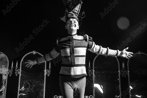 Actor dressed jester's costume in interior of old theater. Black-white portrait.