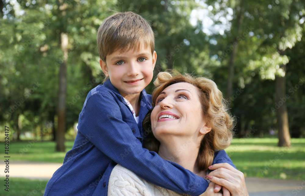 Cute little boy with grandmother in park on sunny day Cute little boy with grandmother in park on sunny day