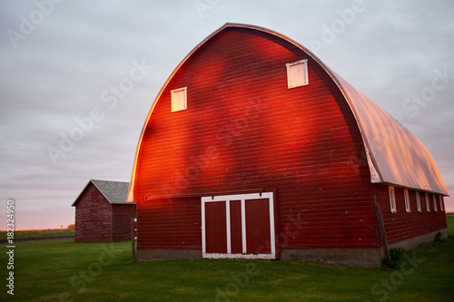 Bright red barn with grey overcast skies overhead photo