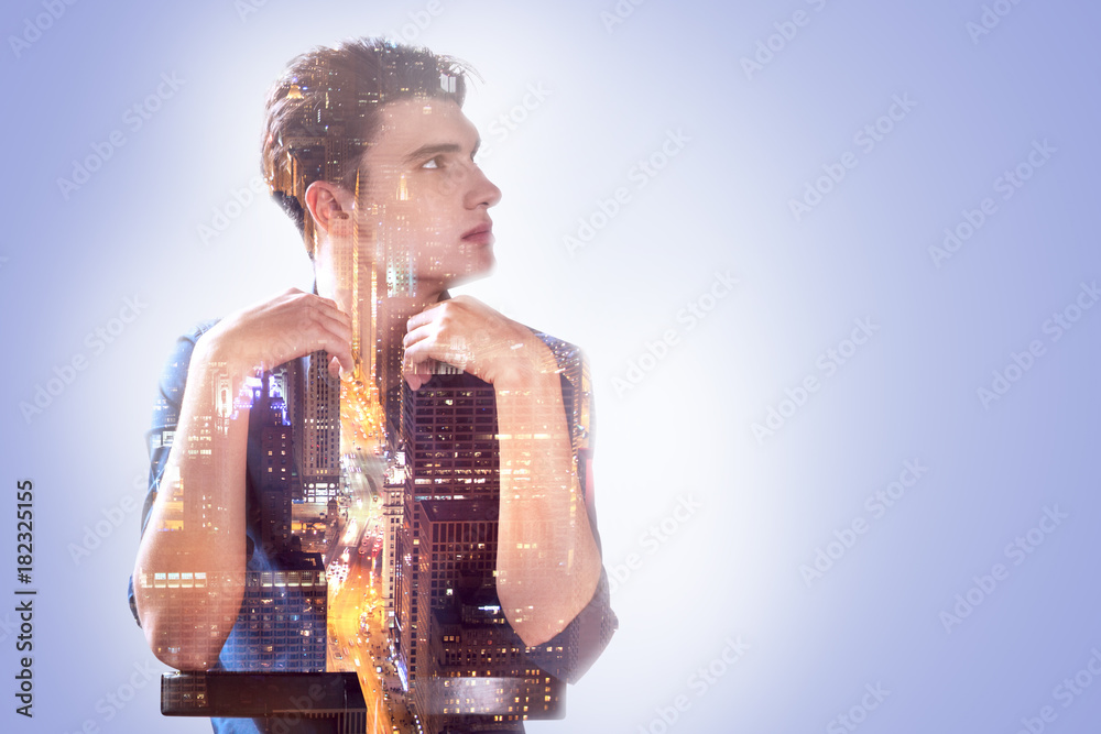 Fototapeta premium Full of thoughts. Handsome pleasant nice man leaning on the chair and looking aside while being full of thoughts