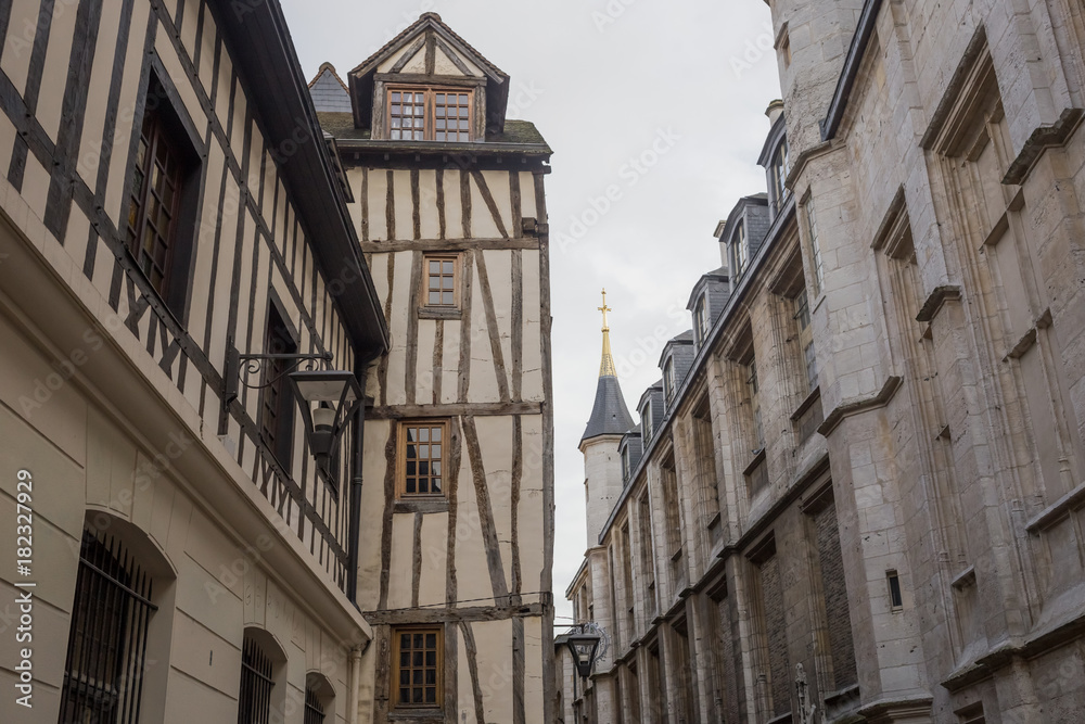 Old and tilted houses at Rue Eau de Robec in Rouen on a rainy day. Rue Eau-de-Robec is one of the main tourist streets of Rouen. Upper Normandy, France.