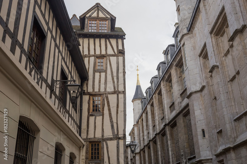 Old and tilted houses at Rue Eau de Robec in Rouen on a rainy day. Rue Eau-de-Robec is one of the main tourist streets of Rouen. Upper Normandy, France.