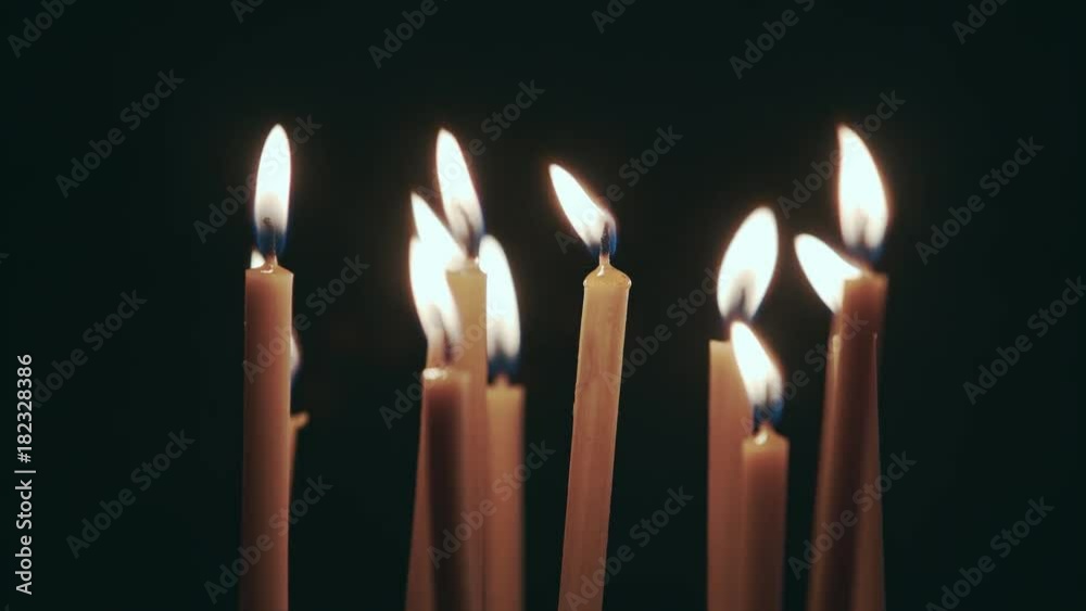 Candles are burning in the spacious room and go out. Black background Candles are burning in the spacious room and go out. Black background
