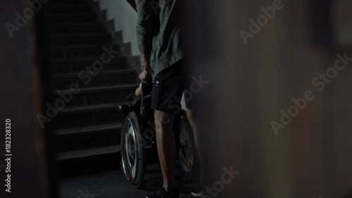 Young father taking care of his disabled child on a wheelchair