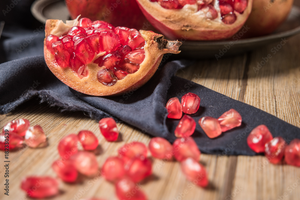 Pomegranate fruit on rustic table Pomegranate fruit on rustic table