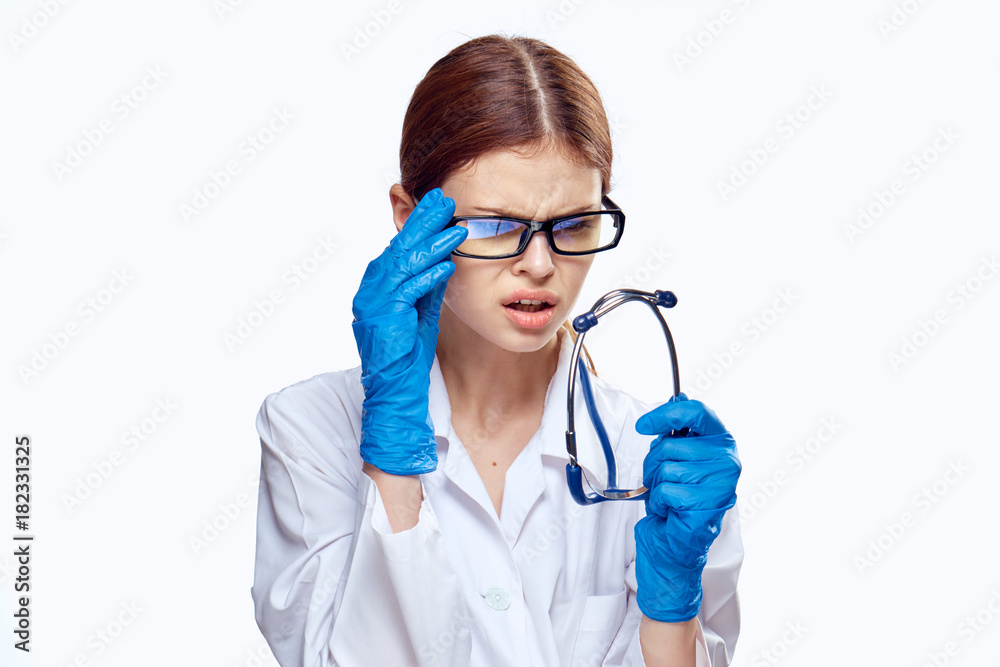 Young beautiful woman on white isolated background in medical dressing gown and glasses, doctor, medicine