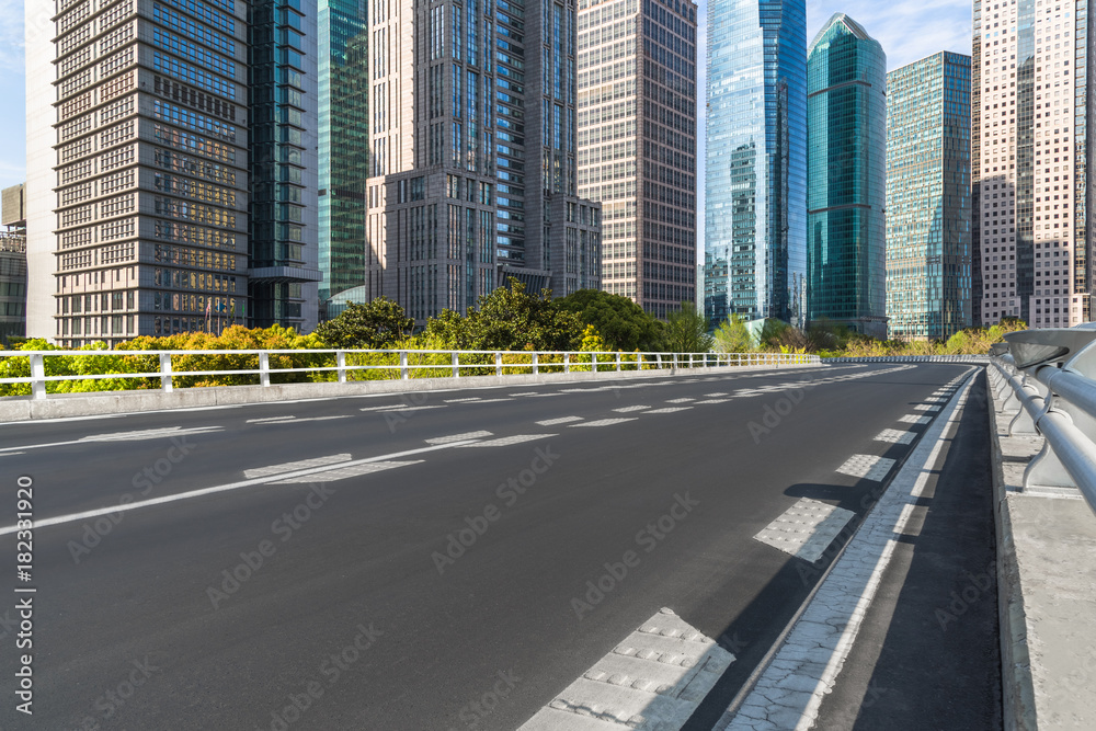 Fototapeta premium empty asphalt road on modern bridge with city skyline background.