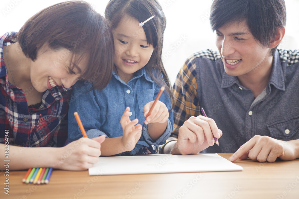 Dad, mommy and daughter are painting with colored pencils. Dad, mommy and daughter are painting with colored pencils.