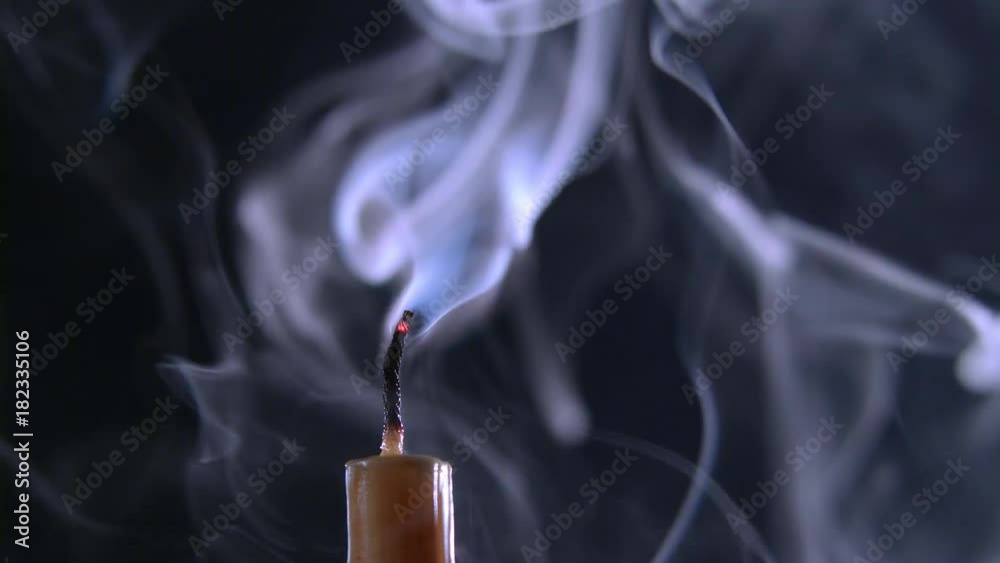 Candle is on and goes out. Black background. Close up