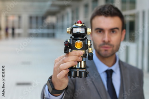 Businessman holding a robot in office space