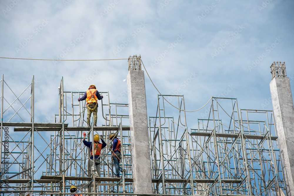 group of worker in safety uniform install reinforced steel column in construction site during sunset time