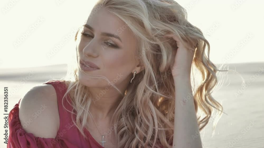 Wonderful smiling woman with a lovely look and natural make up looking at camera and the wind moving her hair Wonderful smiling woman with a lovely look and natural make up looking at camera and the wind moving her hair