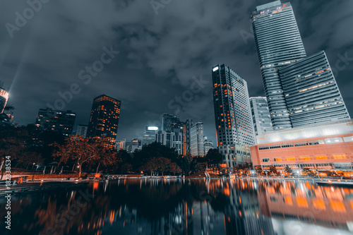 Business district downtown background  skyscrapers reflected in water. Kuala Lumpur City Centre Park at night