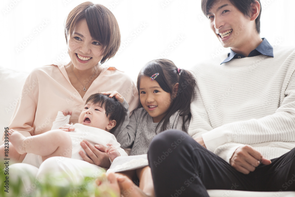Parents, daughter and baby are sitting on the sofa and talking. Parents, daughter and baby are sitting on the sofa and talking.