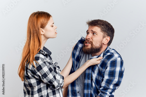 Man with a beard on a white isolated background with a beautiful young woman, emotions
