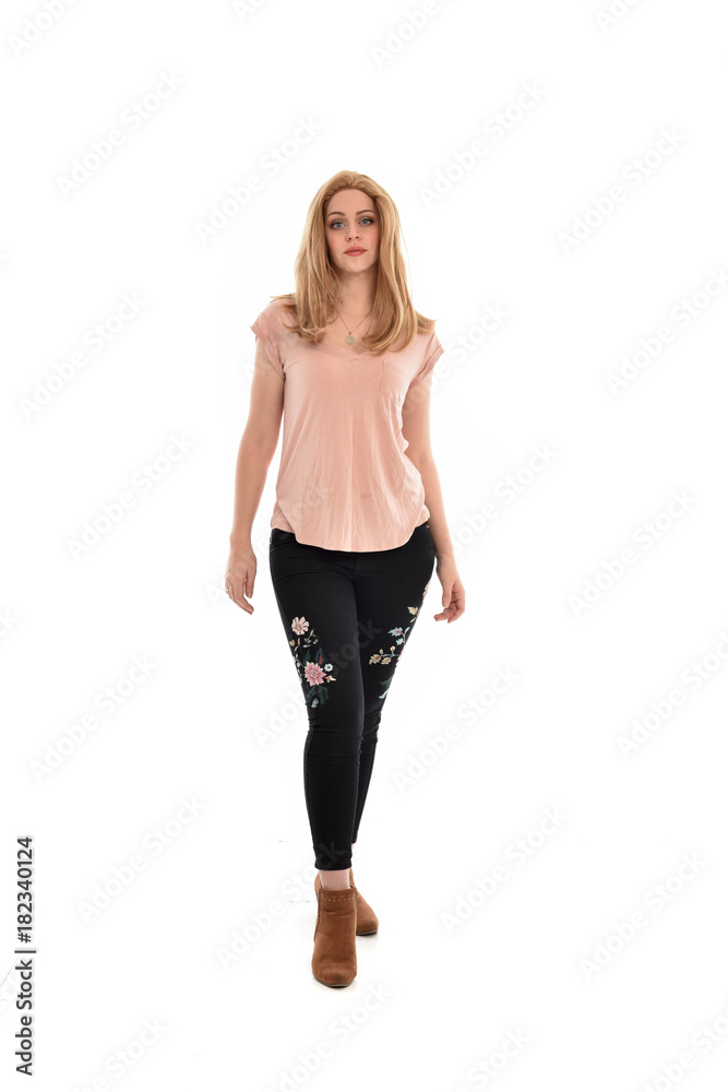 full length portrait of a girl wearing pink shirt and black floral pants. standing pose, isolated on white background. full length portrait of a girl wearing pink shirt and black floral pants. standing pose, isolated on white background.