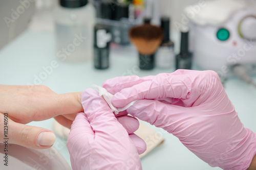 Putting varnish on nails. Processing of nails in beauty shop.