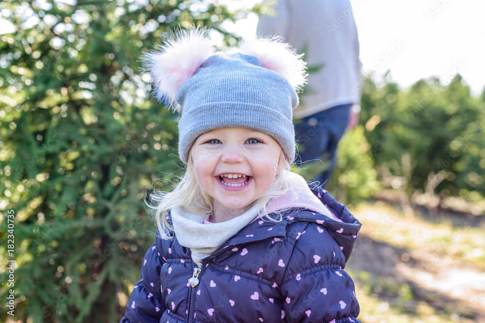 closeup of little girl having fun at christmas tree farm in winter closeup of little girl having fun at christmas tree farm in winter
