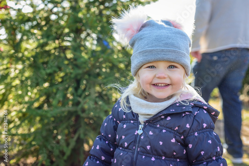 happy little girl outside at Christmas tree lot in winter