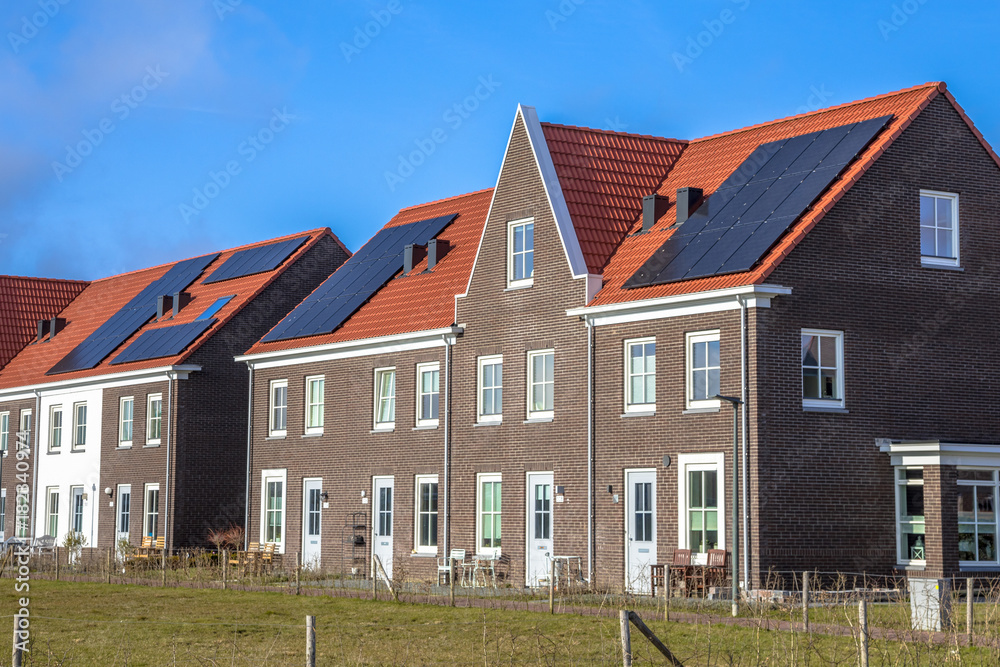 Modern row houses with solar panels on sunny day Modern row houses with solar panels on sunny day