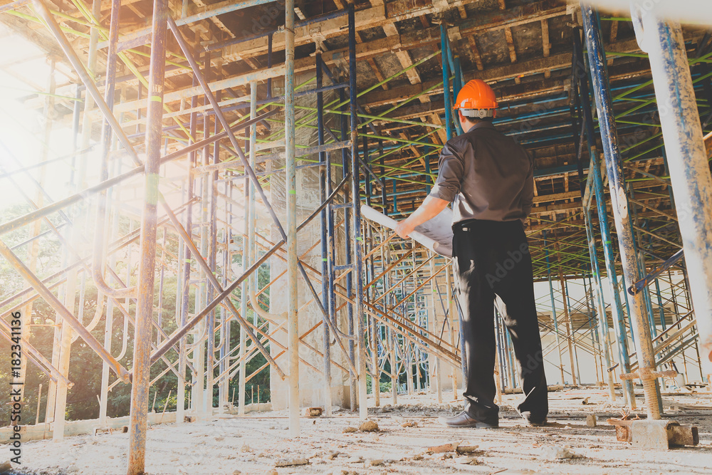 Engineer with blueprint in building construction site