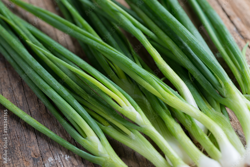 Pile of fresh spring onion on wood table Pile of fresh spring onion on wood table