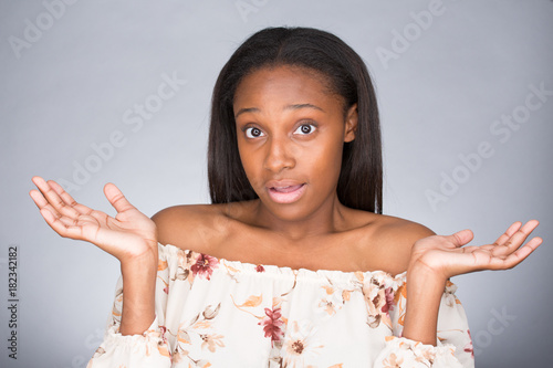 Fotografi Closeup portrait of pretty smiling young woman with arms out asking what's the problem who cares so what or I don't know