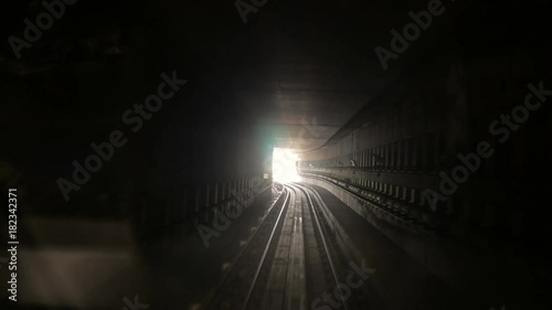 moving camera in dark railway tunnel toward bright light in the end