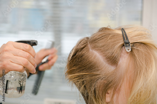 The girl is cut in beauty shop. A hairstyle in beauty shop.