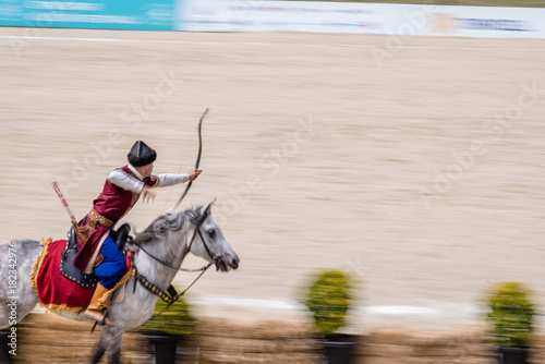 people in costumes of ancient Ottoman Empire archer soldiers shooting at archery competition