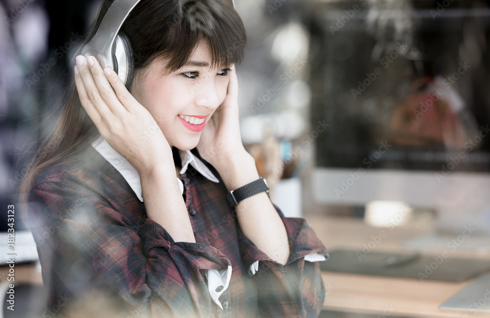 Fototapeta premium Young asian woman listening to music with headphones