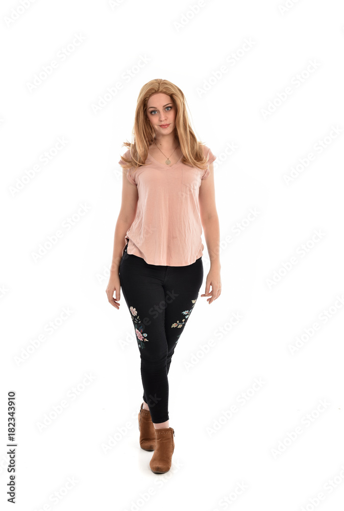 full length portrait of a girl wearing pink shirt and black floral pants. standing pose, isolated on white background. full length portrait of a girl wearing pink shirt and black floral pants. standing pose, isolated on white background.