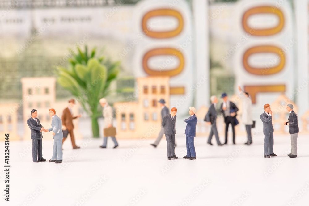 Miniature figurines of businessman with dollar banknote background,business concept Miniature figurines of businessman with dollar banknote background,business concept