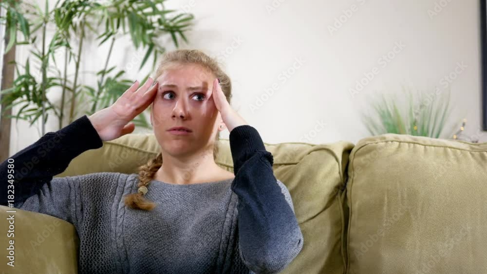 Young Woman suffers from a headache in modern apartment Young Woman suffers from a headache in modern apartment