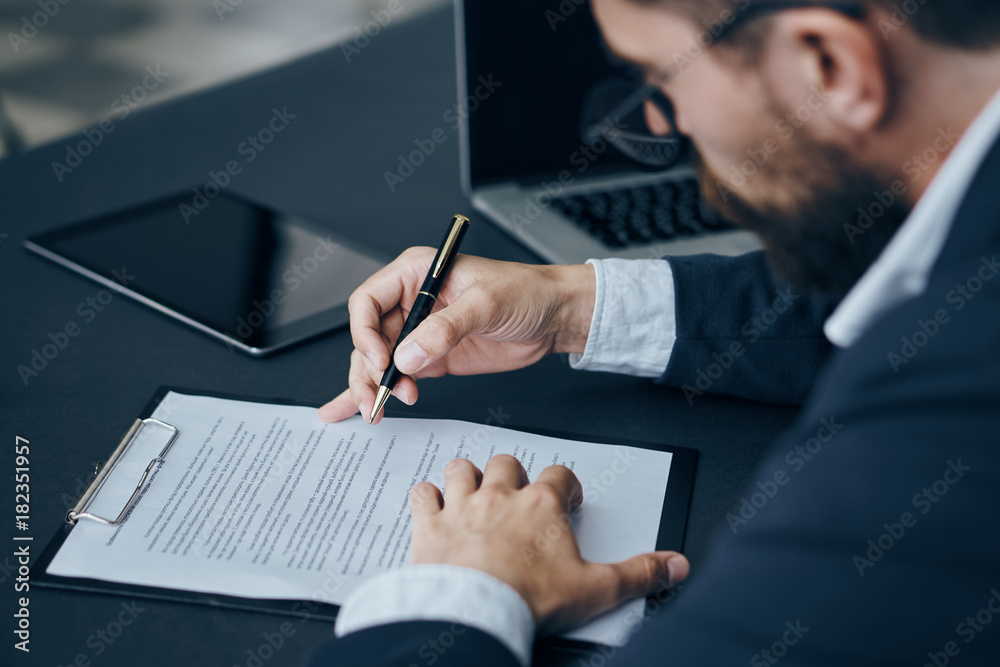Business man with a beard working with documents in the office, writing, working Business man with a beard working with documents in the office, writing, working