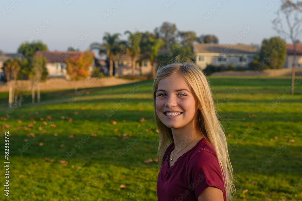 Young female smiling in grass field outdoors Young female smiling in grass field outdoors