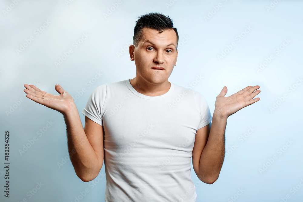 Portrait of a man close-up, who is surprised to spread his hands. On a light background. The concept of human emotions. Portrait of a man close-up, who is surprised to spread his hands. On a light background. The concept of human emotions.