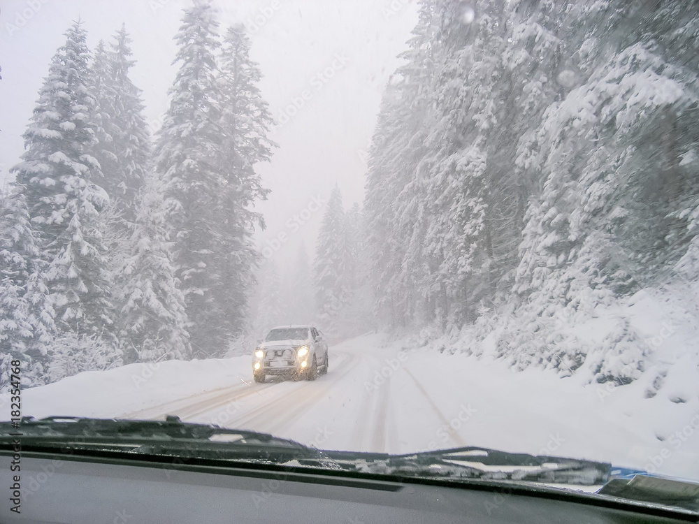 View through the car windshield to the winter mountain road