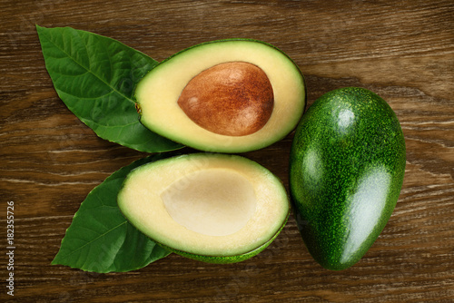 Avocado with leaves on a dark wooden background.