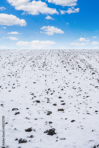 Photo of agricultural field covered with snow in winter