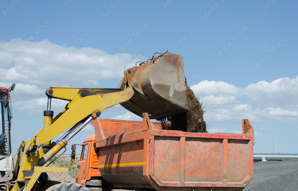 Wheel excavator loading gravel pile